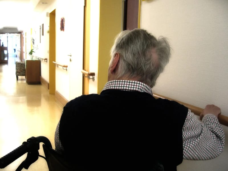 Elderly person in wheelchair in care facility